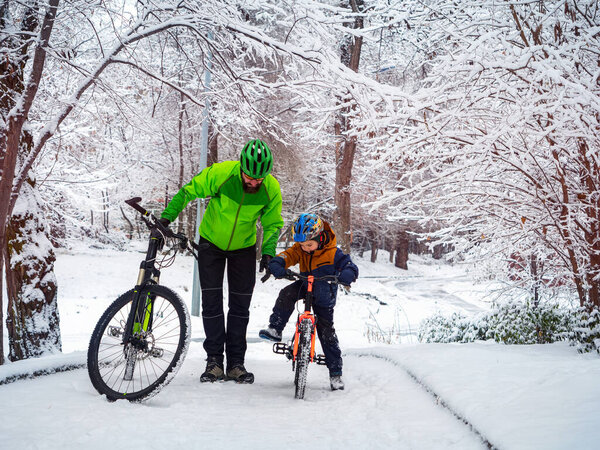 Father and son with bicycles in a winter park