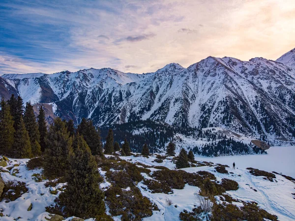 Een reiziger ontmoet dageraad op een bergmeer in de winter — Stockfoto