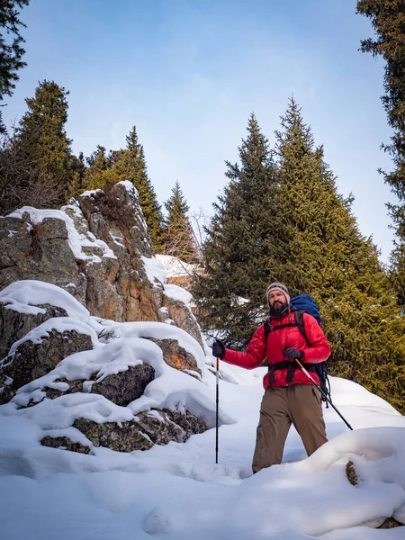 A man in a red jacket walks in the mountains in winter — Stock Photo, Image