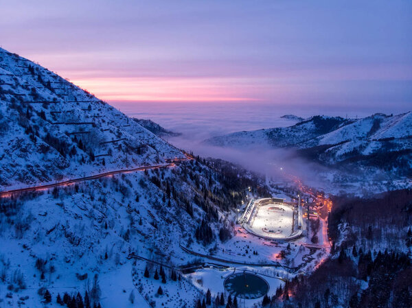 ALMATY, KAZAKHSTAN - FEBRUARY 19, 2020: View of the Medeu ice rink late at night. Winter in the mountains of Zailiysky Alatau. Small Almaty Gorge. Late evening in the mountains
