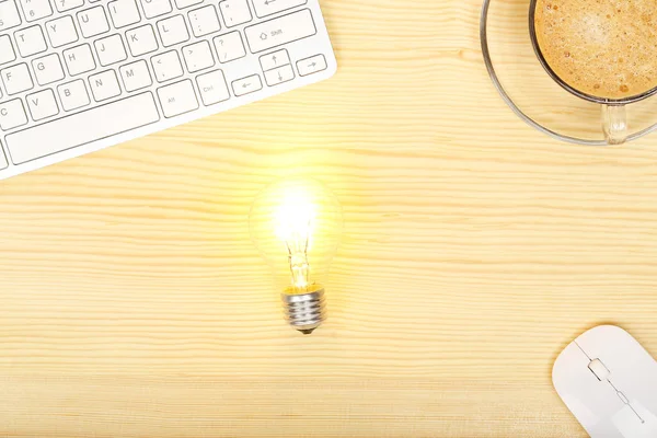 Light bulb on desk — Stock Photo, Image