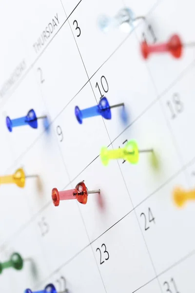 Pushpins on calendar — Stock Photo, Image