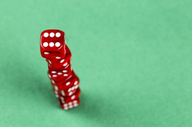 Yeşil keçeli kumaş üzerine kırmızı zar yığını