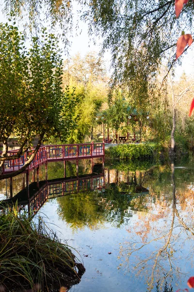 Červený most a altánem u rybníka — Stock fotografie