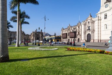 LIMA / PERU - May 10 2016: A Catholic Cathedral in the Plaza de Armas with a horse and buggy and several people in Lima, Peru.