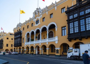 LIMA / PERU - May 10 2016: The front of the municipal building in the Plaza Mayor de Armas with people and vehicles on the street in Lima, Peru.