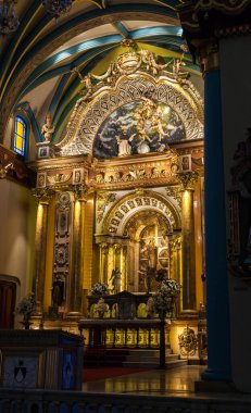 LIMA / PERU - May 10 2016: The interior of a beautifully decorated Catholic Church with elaborate paintings and gold leafing in Lima, Peru.
