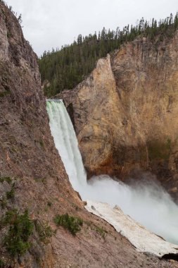 Yellowstone Nehri 'nin yüksek ve güçlü Aşağı Şelaleleri, Wyoming' deki Yellowstone Ulusal Parkı 'nın tepesinde, kimliği belirsiz insanlarla sarp kanyona düşüyor..