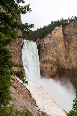 Yellowstone Nehri 'nin yüksek ve güçlü Aşağı Şelaleleri, Wyoming' deki Yellowstone Ulusal Parkı 'nın tepesinde, kimliği belirsiz insanlarla sarp kanyona düşüyor..