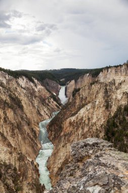 Yellowstone Nehri 'nin yüksek ve güçlü Aşağı Şelalesi Wyoming' deki Yellowstone Ulusal Parkı 'ndaki Sanatçılar Noktasından görüldüğü gibi dik kanyona düşüyor. Yellowstone Ulusal Parkı, Wyoming.