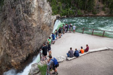 YELLOWONE ULUSAL PARK, ABD - 12 Temmuz 2014: Turistler 12 Temmuz 2014 tarihinde Yellowstone Ulusal Parkı, Wyoming 'deki Yellowstone Nehri' ndeki Lower Falls 'un tepesine çıkıp oturdular.