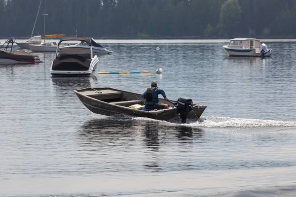 2014年7月17日 ワイオミング州グランド テトン国立公園のジャクソン湖にあるコルターベイ マリーナを出発する小型ボートの男 — ストック写真