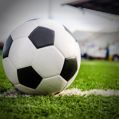 Futbol topu futbol sahası yeşil çimenlerin üzerinde.