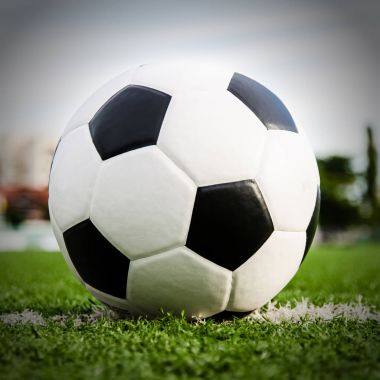 Futbol topu futbol sahası yeşil çimenlerin üzerinde.