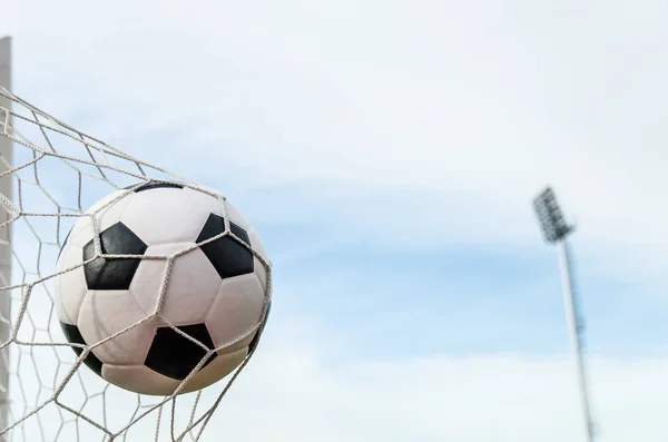 Football football dans le filet de but avec le champ de ciel . — Photo