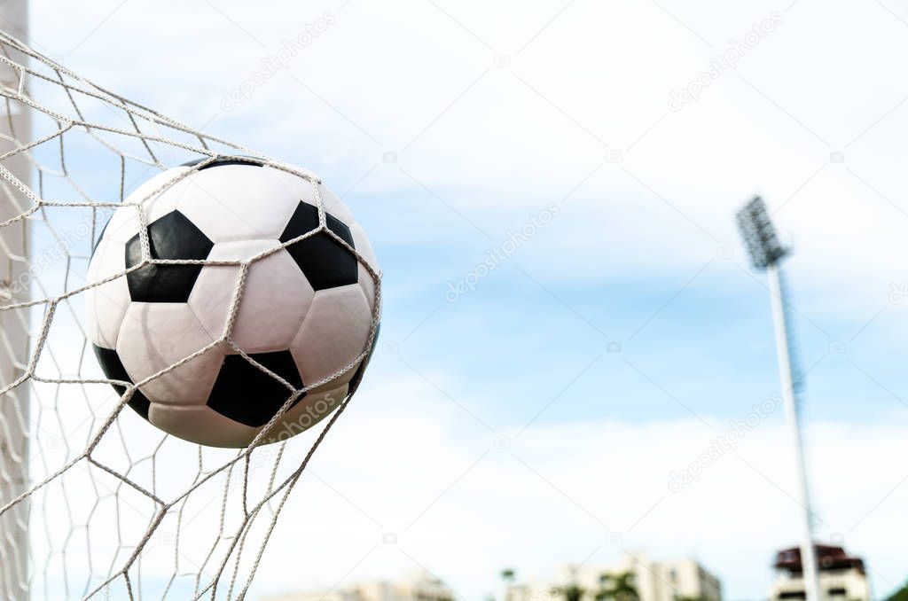 Soccer football in Goal net with the sky field.