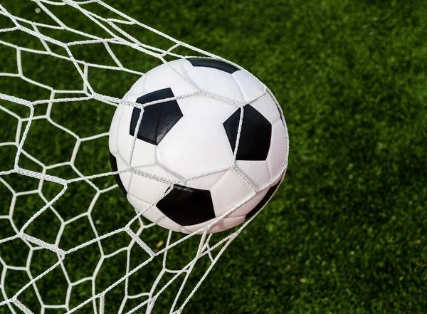 Fútbol fútbol en Goal net con campo de hierba verde . — Foto de Stock