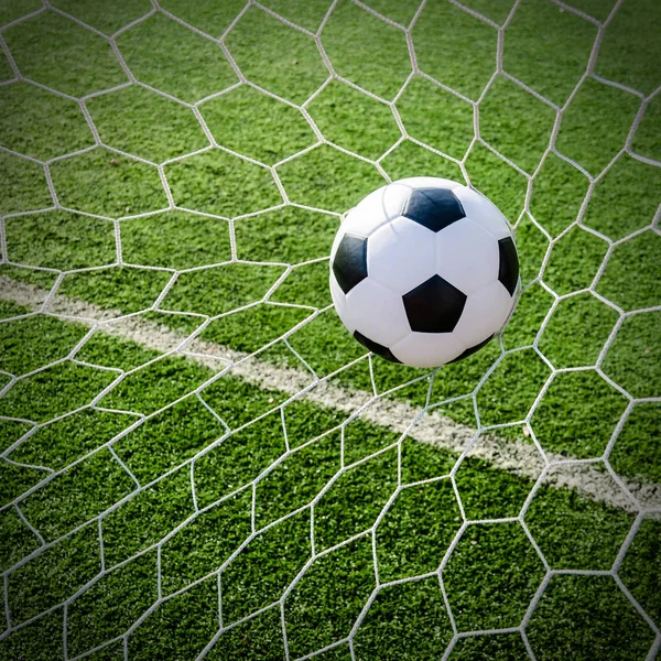 Soccer football in Goal net with green grass field. — Stock Photo, Image