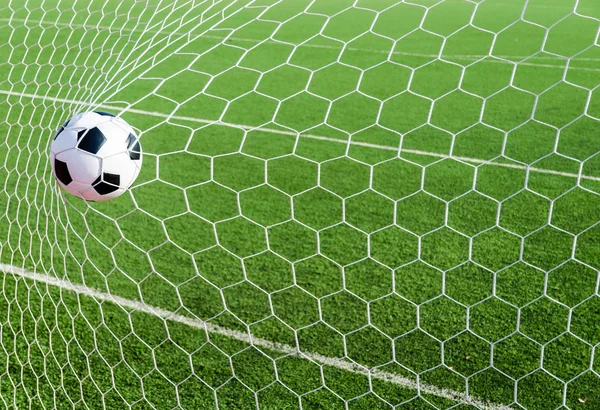 Soccer football in Goal net with green grass field. — Stock Photo, Image