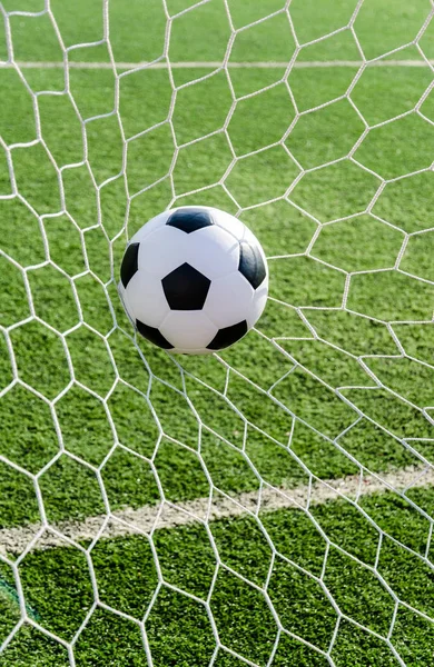 Fútbol fútbol en Goal net con campo de hierba verde . — Foto de Stock