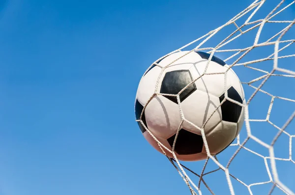 Voetbal voetbal in doel net met de hemel veld. — Stockfoto