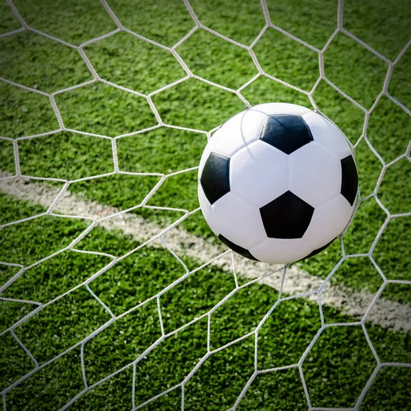 Voetbal voetbal in doel netto met groen grasveld. — Stockfoto
