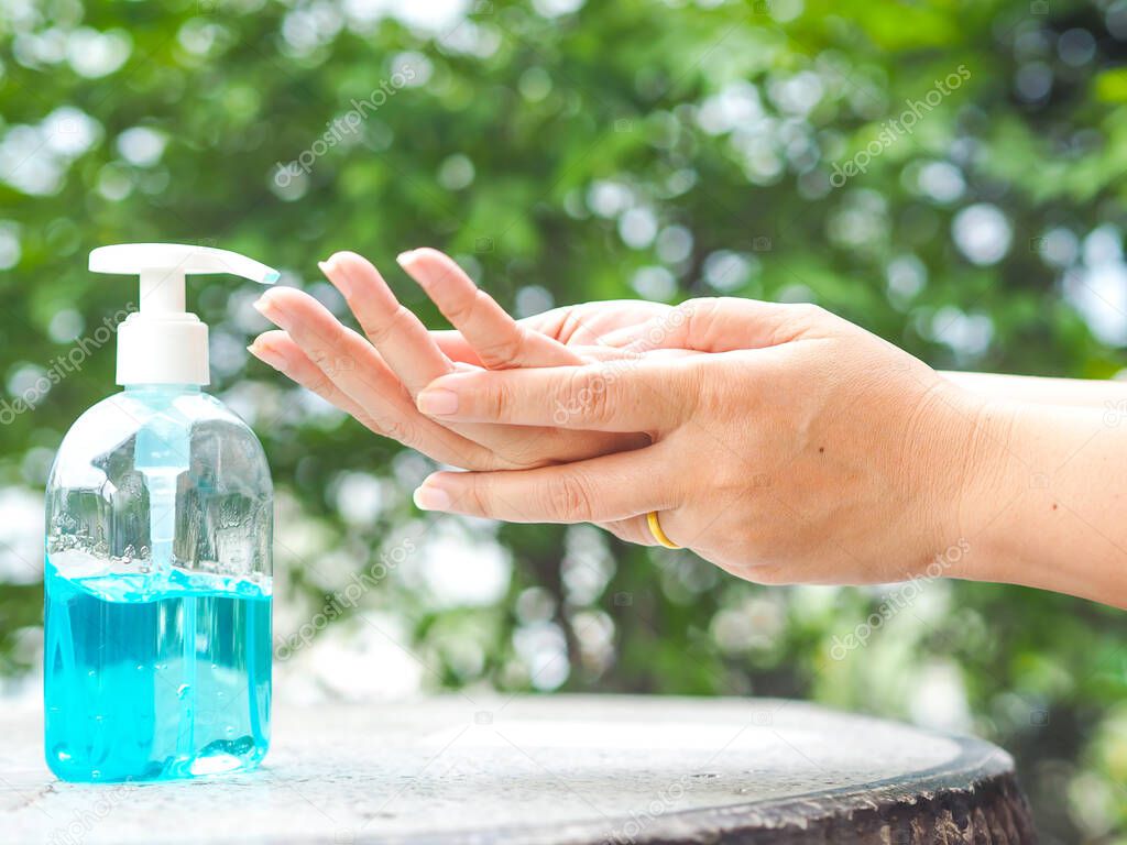 Woman's hands is pressing a bottle of Alcohol Gel to clean her hands. Alcohol gel is very important in daily life.