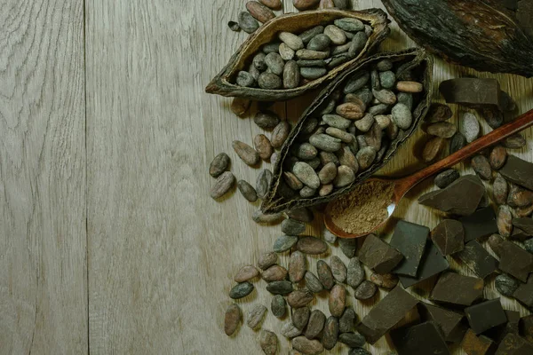 Open cocoa fruit lies on a wooden table with cocoa beans — Stock Photo, Image