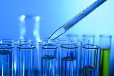 Pipette numuneyi test tüpüne bırakıyor mavi ışık