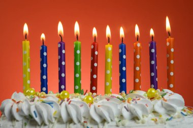 multi-colored candles burn on a birthday cake