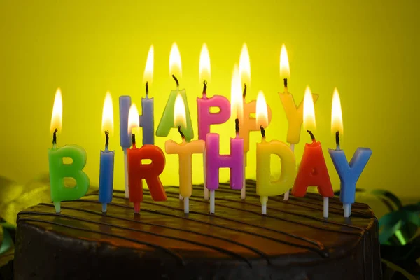 Torta di compleanno con candele su sfondo giallo — Foto Stock