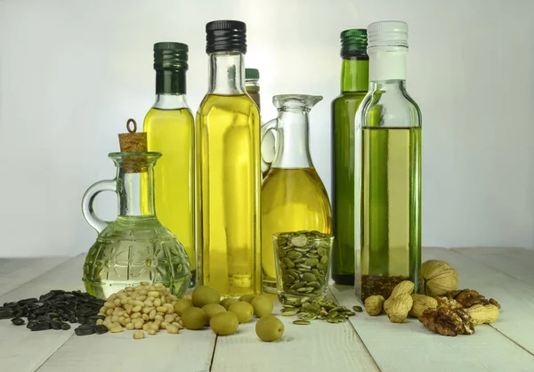 Varias botellas de diferentes soportes de aceite sobre una mesa de madera — Foto de Stock