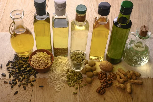 Verschillende flessen van verschillende oliestandaard op een houten tafel — Stockfoto