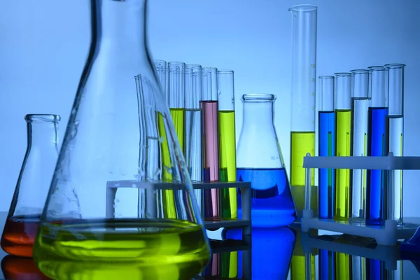 Flasks and test tubes stand in a laboratory with colored chemical liquids — Stock Photo, Image