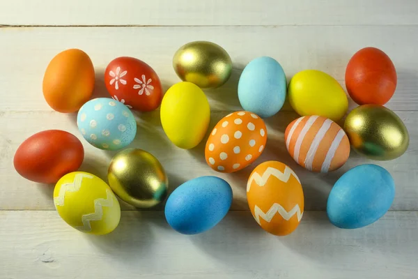 Easter colored eggs lie on a wooden table