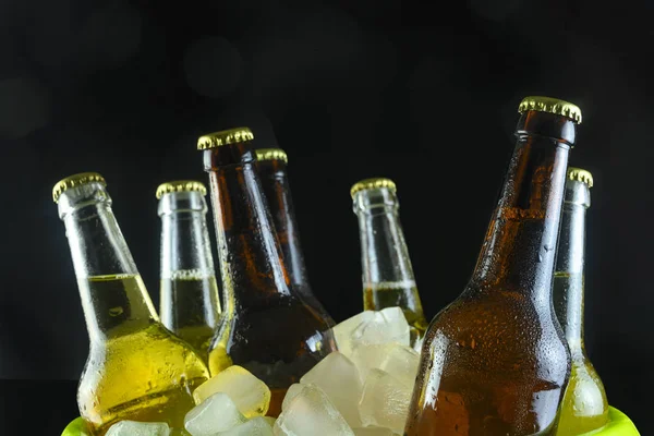 Siyah arka planda buz olan kovadaki bira şişeleri. — Stok fotoğraf
