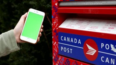 Kanada posta kutusunun yeşil ekran iphone tutan kadın 