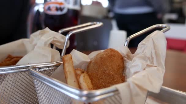 Крупним планом жінка кладе перець на картоплю фрі та курячу смужку в ресторані A&W — стокове відео