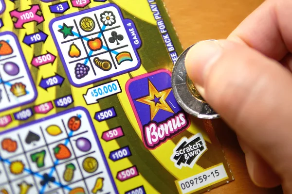 Close-up van man scratching loterij ticket op de bonus sectie. — Stockfoto
