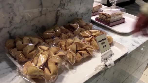 Movimiento de la mujer tomando galletas de la fortuna dentro de la panadería Saint Germain — Vídeo de stock