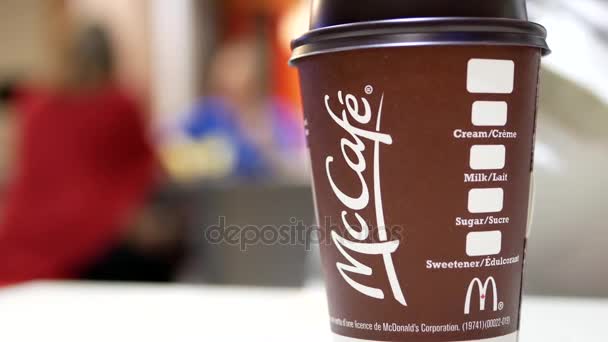 Close-up van warme koffie van de Mccafe mcdonalds fastfood restaurant met vervaging beweging achtergrond — Stockvideo