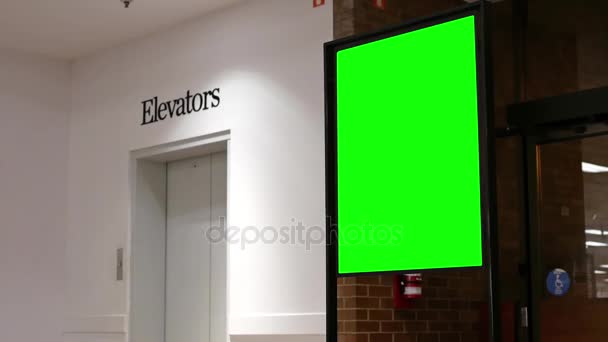 Green billboard for your ad beside elevators — Stock Video