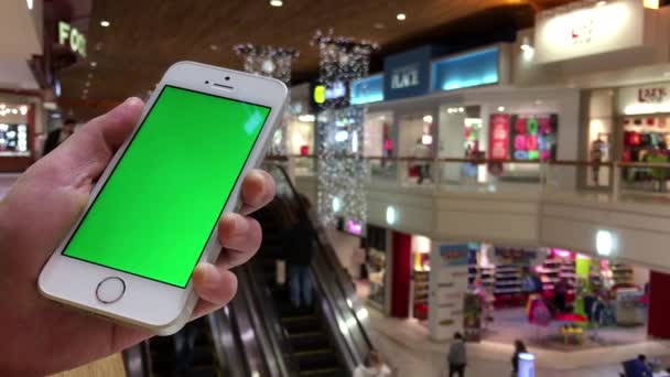 Mulher segurando telefone celular tela verde ao lado escada rolante dentro Coquitlam shopping center — Vídeo de Stock