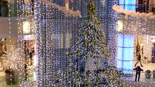 模糊镜头与圣诞灯商场内购物的人们被装饰的议案倾斜建筑全. — 图库视频影像