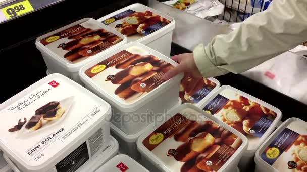 Beweging van mensen selecteren van papavers mini eclairs binnen superstore — Stockvideo