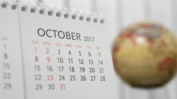 Movimiento de octubre 2017 calendario con globo de tierra borrosa girando fondo — Vídeo de stock