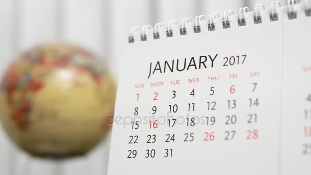 Bewegung des Januars 2017 Kalender mit verschwommenem Erdglobus — Stockvideo