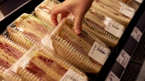 女性ハム、スイスチーズ サンドイッチ価格スマート食品ストア内の購入. — ストック動画