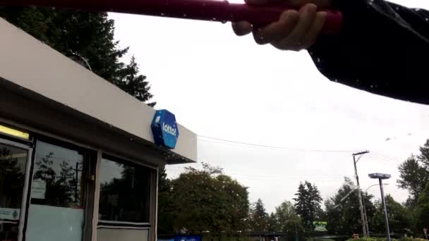Vista interior de la gente limpiando el parabrisas del coche en la gasolinera esso — Vídeos de Stock