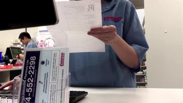 Närbild Costco apotek räknare med apotekspersonal kontrollera information för kunden — Stockvideo
